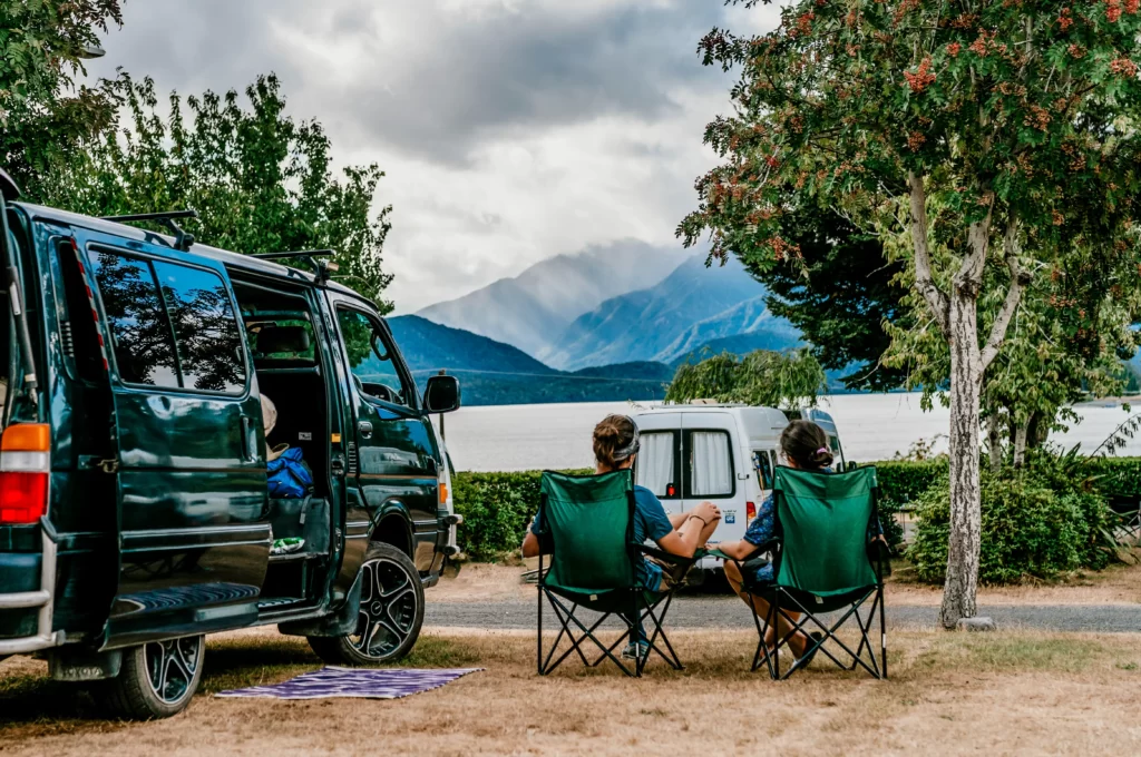 Young couple looking at Lake Te Anau from camp site in holiday park