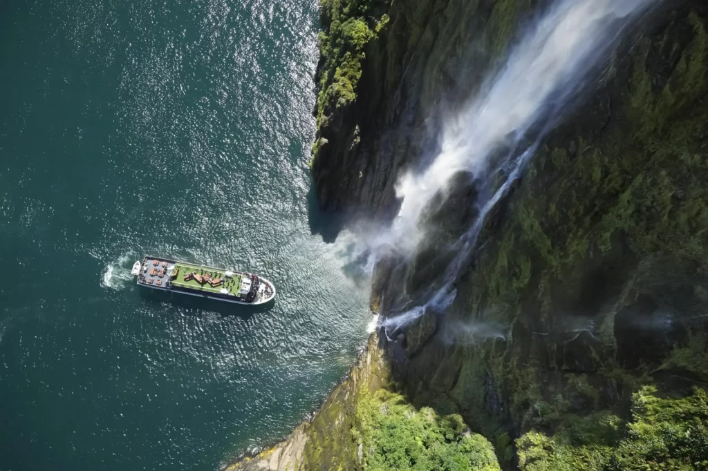 The Milford Haven cruise poking nose into waterfall in Milford Sound