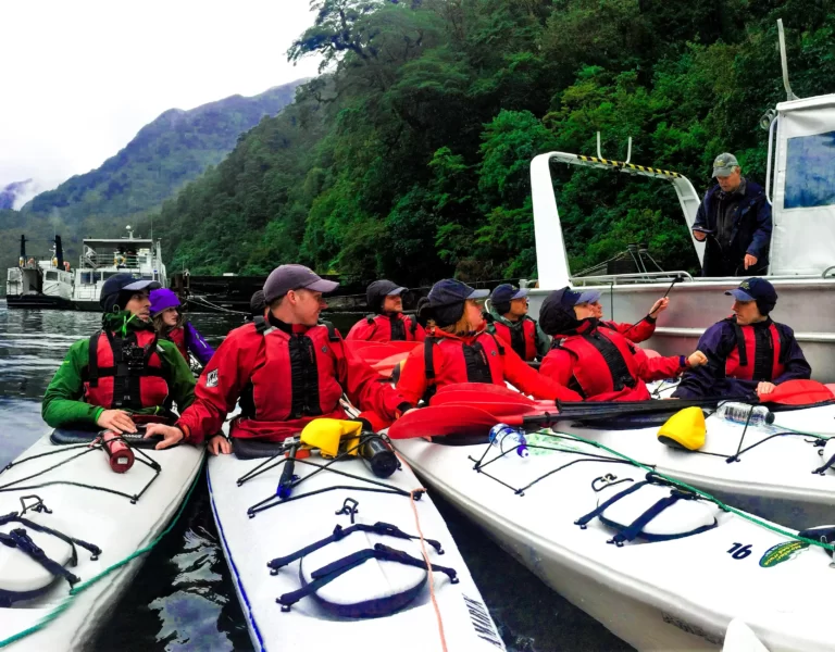 Group of kayakers recieiving instructions in Fiordland