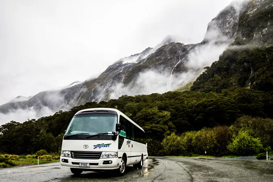 Tracknet bus driving amongst misty mountains of Fiordland