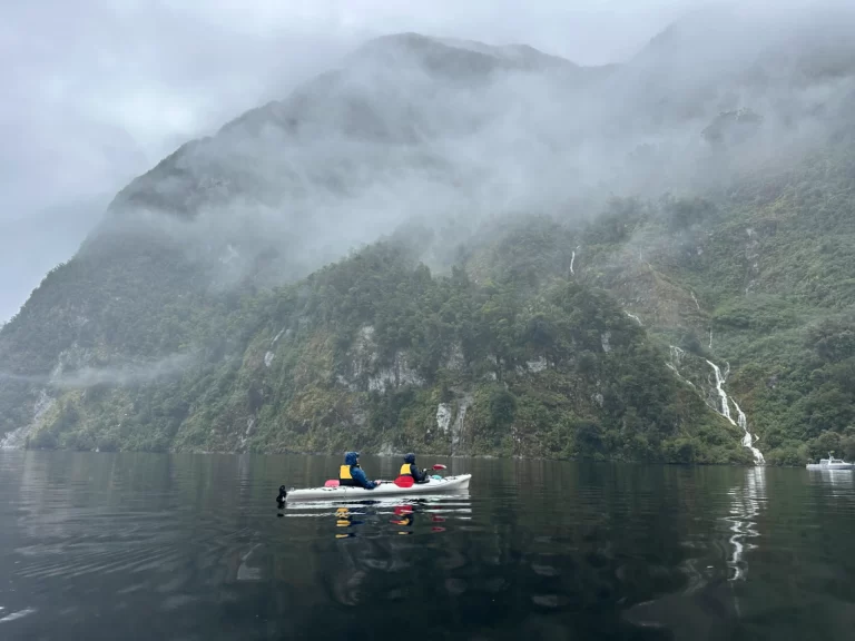 Kayakers in a misty Doubtful Sound